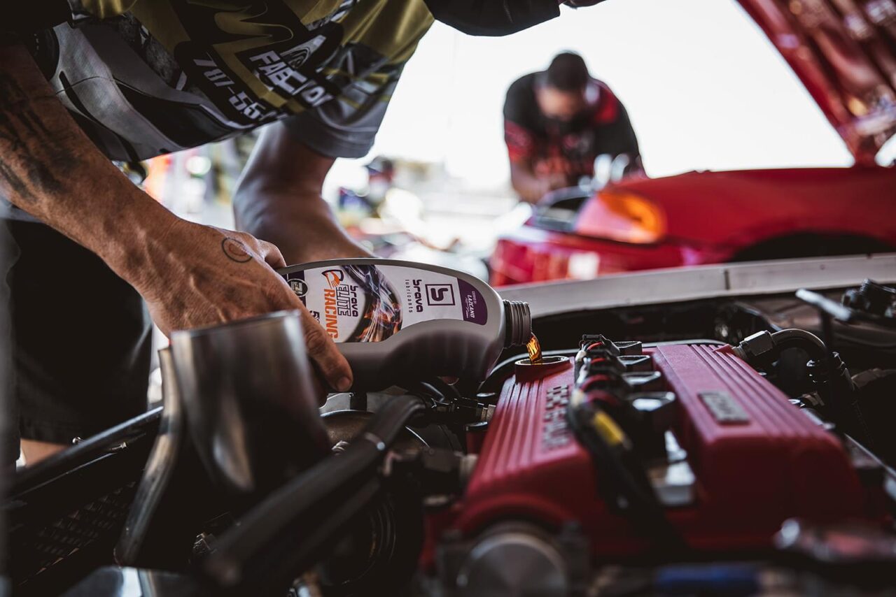 Man pouring Brava elite racing oil into an engine