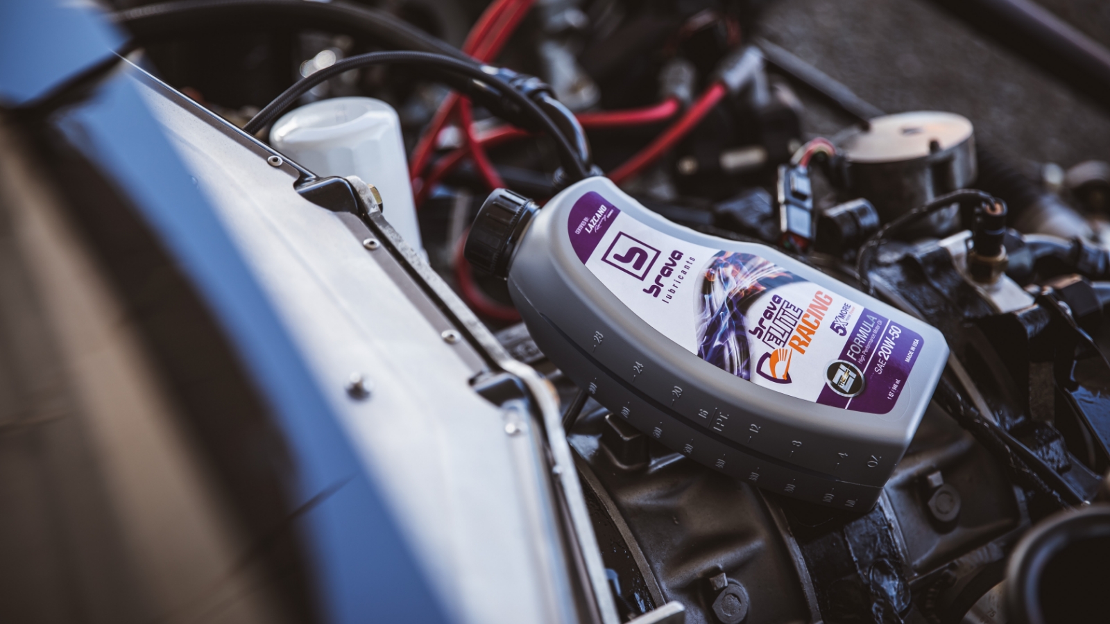 product bottle of brava elite racing oil featured on top of an engine