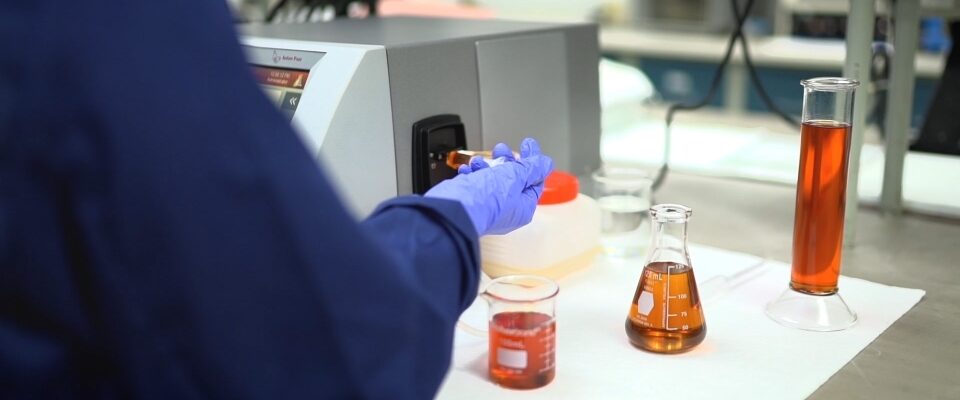 técnico de laboratorio midiendo diferentes lubricantes en vasos de precipitados