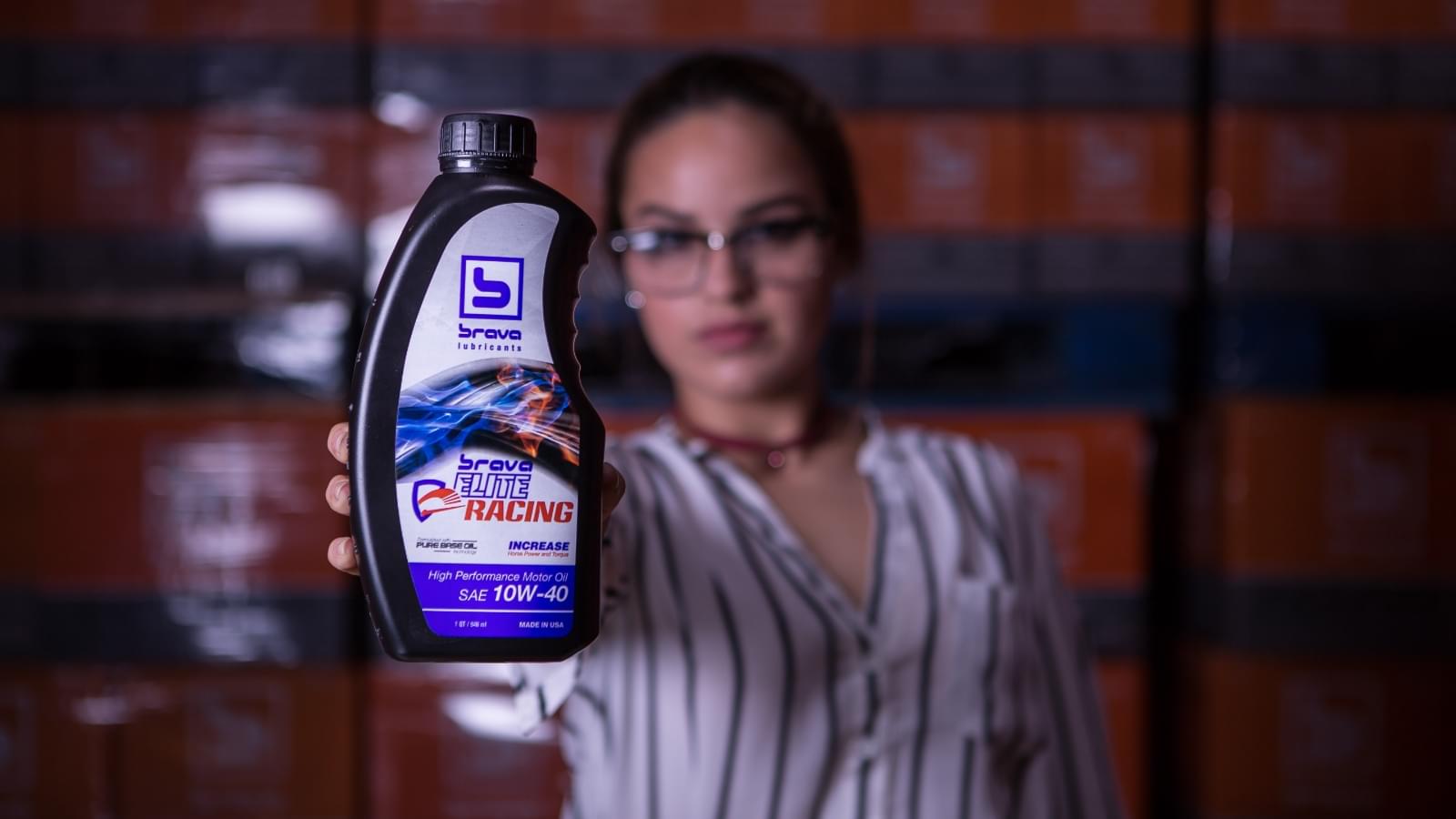 woman holding brava elite racing oil product bottle